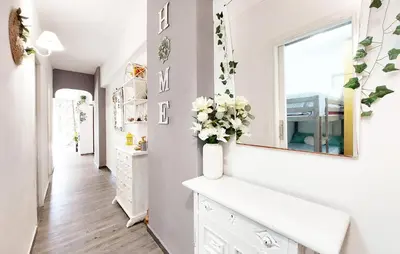 a bathroom with a white vanity and a vase of flowers at Nice Apartment In Puebla De Farnals in Puebla de Farnals