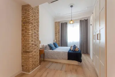 a bedroom with a bed and a brick wall at Apartment with terrace in Extramurs in Valencia