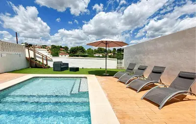 a pool with chairs and an umbrella on a patio at Amazing Home In Turís in Turís