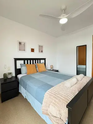 a bedroom with a large bed with a blue comforter at UIM Mediterraneo Alpuente Wifi in Puerto de Sagunto
