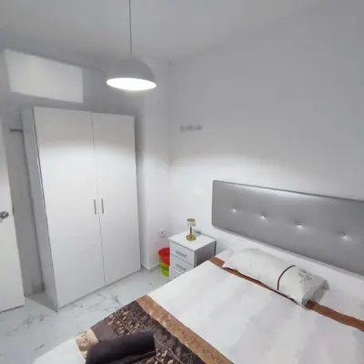 a white bedroom with a bed and a white cabinet at Rooms Ciudad Bella in Valencia