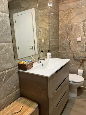 a bathroom with a sink and a mirror and a toilet at Estupendo apartamento en Llíria in Lliria