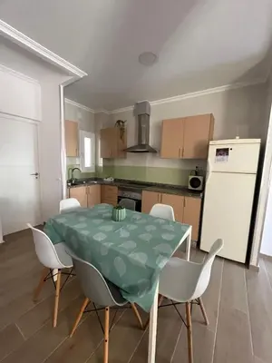 a kitchen with a table and chairs and a refrigerator at Estupendo apartamento en Llíria in Lliria
