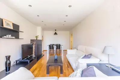 a living room with a white couch and a tv at Invalencia - Primado Reig Suite in Valencia