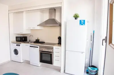 a kitchen with white cabinets and a refrigerator at VLC Host - Cuber Apartments in Valencia