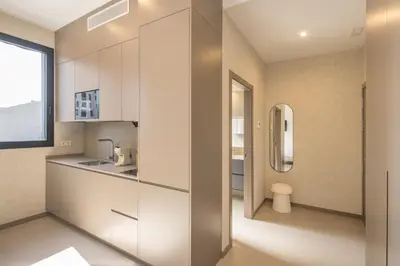a kitchen with white cabinets and a sink at Housing Maritim by SharingCo in Valencia