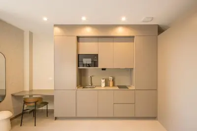a kitchen with white cabinets and a table at Housing Maritim by SharingCo in Valencia