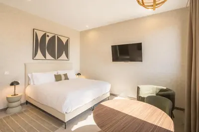 a bedroom with a bed and a tv and a chair at Housing Maritim by SharingCo in Valencia
