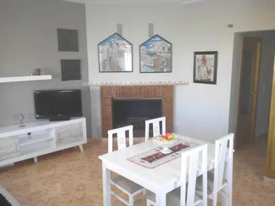 a living room with a table and a fireplace at Ca Erik in Mareny Barraquetas