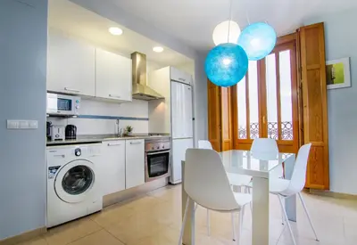 a kitchen with a white table and a dining room at VLC Host - Poeta Llombart in Valencia