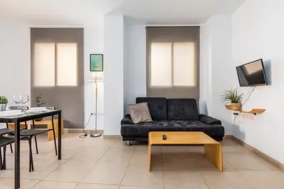 a living room with a black couch and a table at VLC Host - Poeta Llombart in Valencia