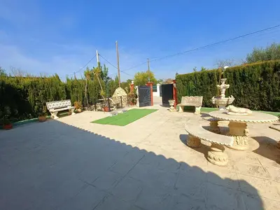 a patio with a fountain and benches in a yard at Beautiful bedroom Country Villa with swimming pool in Lliria