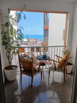 a balcony with a table and chairs and a view of the ocean at El Faro de Nules in Mascarell