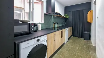 a kitchen with a washing machine and a microwave at Faro de Nules in Mascarell