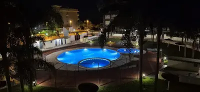 a large swimming pool at night with lights at Apartamento Timia OASIS in Canet de Berenguer
