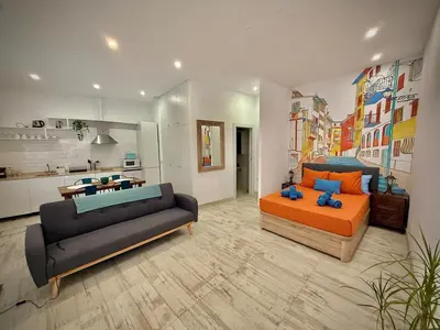a living room with a couch and a bed and a kitchen at Loft Boutique 2 next to Torres de Serrano in Valencia