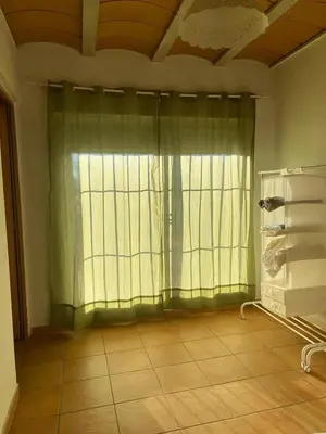 a room with a window with green curtains and a tile floor at Chalet en la naturaleza in Macastre
