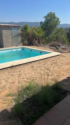 a swimming pool in front of a house at Chalet en la naturaleza in Macastre