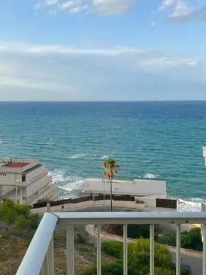 a table with two chairs and two glasses of orange juice at Apartment with sea view in Cullera in Faro de Cullera