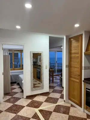 a room with a bedroom with a view of the ocean at De frente al mar in Sueca