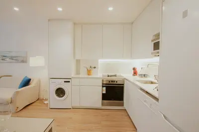 a white kitchen with a washing machine and a sink at Apartamento Familiar En Valencia Centro - Plaza Ayuntamiento in Valencia