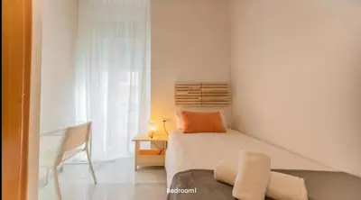 a white bedroom with a bed and a chair at Your apartment in the heart of Valencia in Valencia