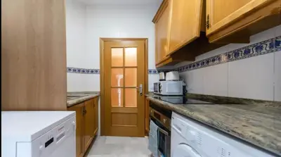 a kitchen with wooden cabinets and a white appliance at Your apartment in the heart of Valencia in Valencia