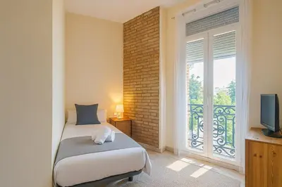 a bedroom with a bed and a window with a television at Apartment in the center of Valencia in Valencia