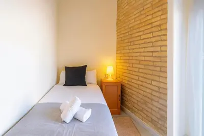 a bedroom with two beds and a brick wall at Apartment in the center of Valencia in Valencia