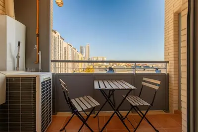 two chairs and a table on a balcony with a view at Tu refugio moderno en Valencia - piscina, gimnasio y padel incluidos in Valencia