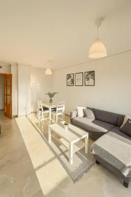 a living room with a couch and a table at Cortes Suite - Pool paddle tennis court and gym in Valencia