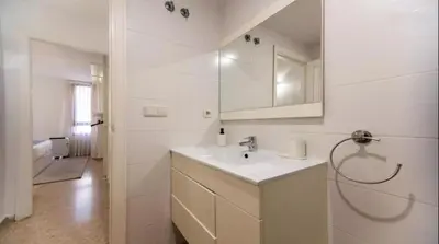 a white bathroom with a sink and a mirror at Historic Center - Loft in the heart of Valencia in Valencia