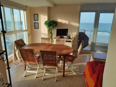 a dining room with a table and chairs and the ocean at Casa Xalera in Mareny Barraquetas