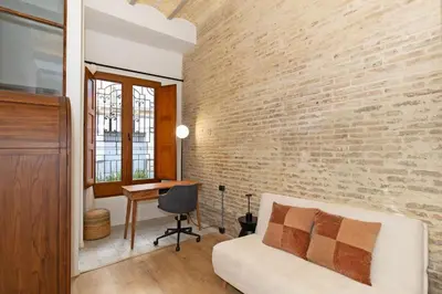 a living room with a white couch and a brick wall at Guestready - Bright stay at Cabanyal in Valencia