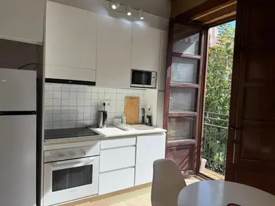 a kitchen with white appliances and a table and a window at Precioso Loft en la Ciutat Vella en Valencia in Valencia