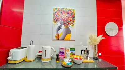 a kitchen counter with a table with a painting of a woman at Ubicación ideal, entre la playa y el centro ciudad in Valencia
