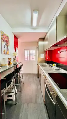a kitchen with red cabinets and a counter top at Ubicación ideal, entre la playa y el centro ciudad in Valencia