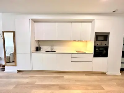 a kitchen with white cabinets and a sink at Turia view apartment in Valencia