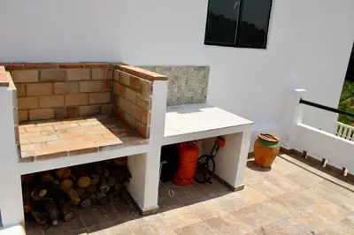 a white bench sitting next to a brick wall at Estudio Finca Mas el Bravo in Caudiel
