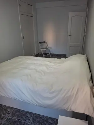 a white bed in a room with a chair at Sea and Sun con vistas a la playa San Antoni in Cullera