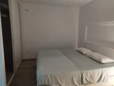 a bedroom with a bed with white sheets and pillows at Encanto de Valencia in Cuart de Poblet