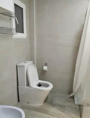 a white bathroom with a toilet and a sink at Encanto de Valencia in Cuart de Poblet