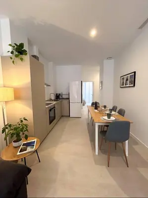 a living room with a table and a kitchen at Hermoso apartamento en Nazaret in Valencia