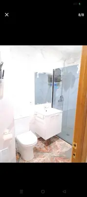 a white bathroom with a toilet and a sink at Habitación con dos camas para dos personas in Valencia