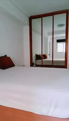 a bedroom with a white bed and a mirror at Habitación cómoda in Valencia