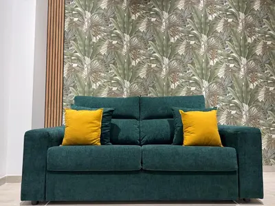a green couch with two yellow pillows in a room at El Jardín de Darío in Valencia