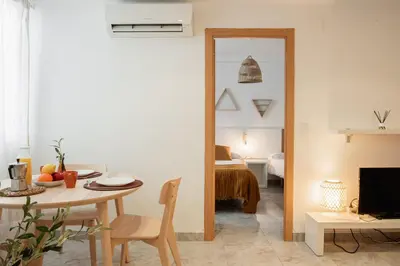 a living room with a table and a bedroom at Apartamentos FV Flats Valencia - Mestalla 5 in Valencia