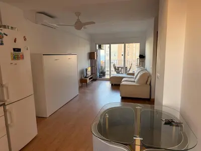 a living room with a glass table and a refrigerator at Apartmento en 5 Mares in Puebla de Farnals