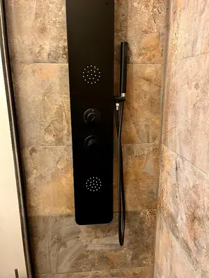 a shower door with a black handle on a stone wall at Apartamento acogedor frente a Plaza de la Iglesia in Valencia