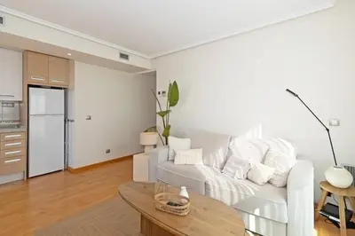 a white living room with a white couch and a table at GuestReady – Modern Flat with Terrace in Valencia in Valencia
